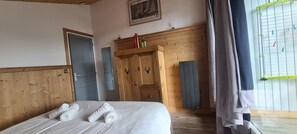 Ein Hotelzimmer mit Bett, Holzschrank und Radiator.