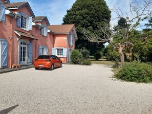 Ein Haus mit Schotterweg und einem geparkten Auto.