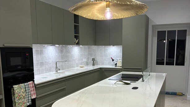 A modern kitchen with a large island, grey cabinets, a microwave, and a hanging pendant light. - 🌸 La Maison Rose – Your Dream French Countryside Escape 🌸 (Marsac)
