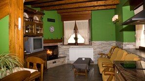 Un salon chaleureux avec une cheminée, des meubles en bois et un téléviseur.