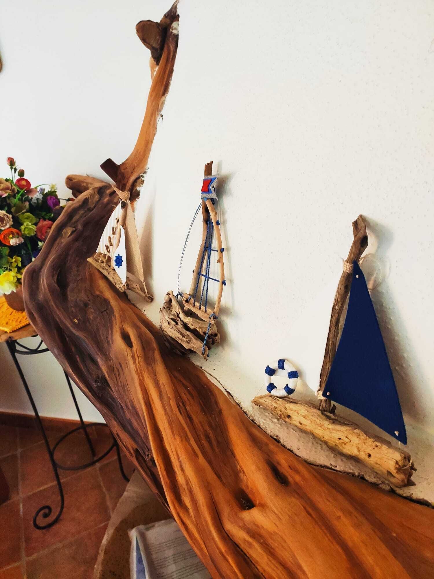 A wooden sculpture of a ship with sails and a figurehead, mounted on a wall.