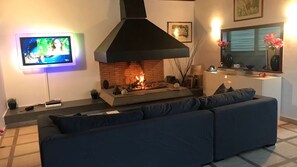 Smart-tv, een open haard, een videogameconsole en tafelvoetbal