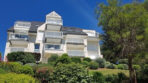 A multi-story residential building with balconies, a flat roof, and a garden in front. - Residential flat- ST-CAST-LE-GUILDO (Saint-Cast-le-Guildo)