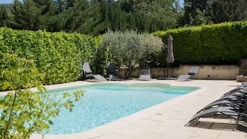 Una piscina al aire libre, una piscina climatizada, tumbonas