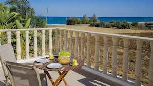 Un balcón con una mesa para dos, con vista a la playa.