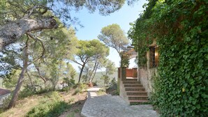 Un chemin de pierres menant à un bâtiment doté d’un escalier en bois.