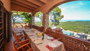 Un coin repas avec une table dressée pour quatre personnes, offrant une vue sur un paysage pittoresque.