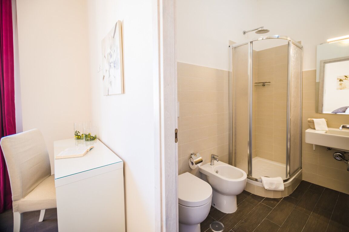 Une salle de bain moderne avec une douche à parois de verre, un lavabo blanc et des toilettes.