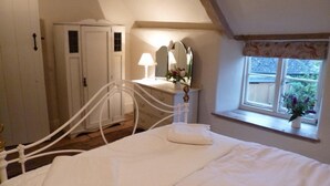 Un dormitorio con cama, cómoda, espejo y ventana con vistas al exterior.