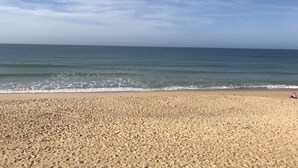 A sandy beach with gentle waves and a clear sky.