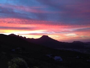 A mountainous landscape with a sunset.