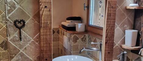 A bathroom with a wooden vanity, a large mirror, and a white sink.