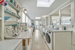 A kitchen with a washing machine, a sink, and a window. - Lumiere - West Wittering (West Wittering, West Sussex)