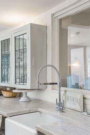 A kitchen with a white cabinet, a stainless steel faucet, and a 'BUTLER TR' sign. - Lumiere - West Wittering (West Wittering, West Sussex)