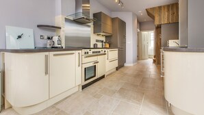 A modern kitchen with a central island, built-in oven, and stainless steel appliances.