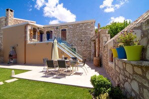A stone building with a patio, outdoor seating, and a staircase. - Blue Paradise villa With Pool And Jacuzzi For 5 People  (rethymno)