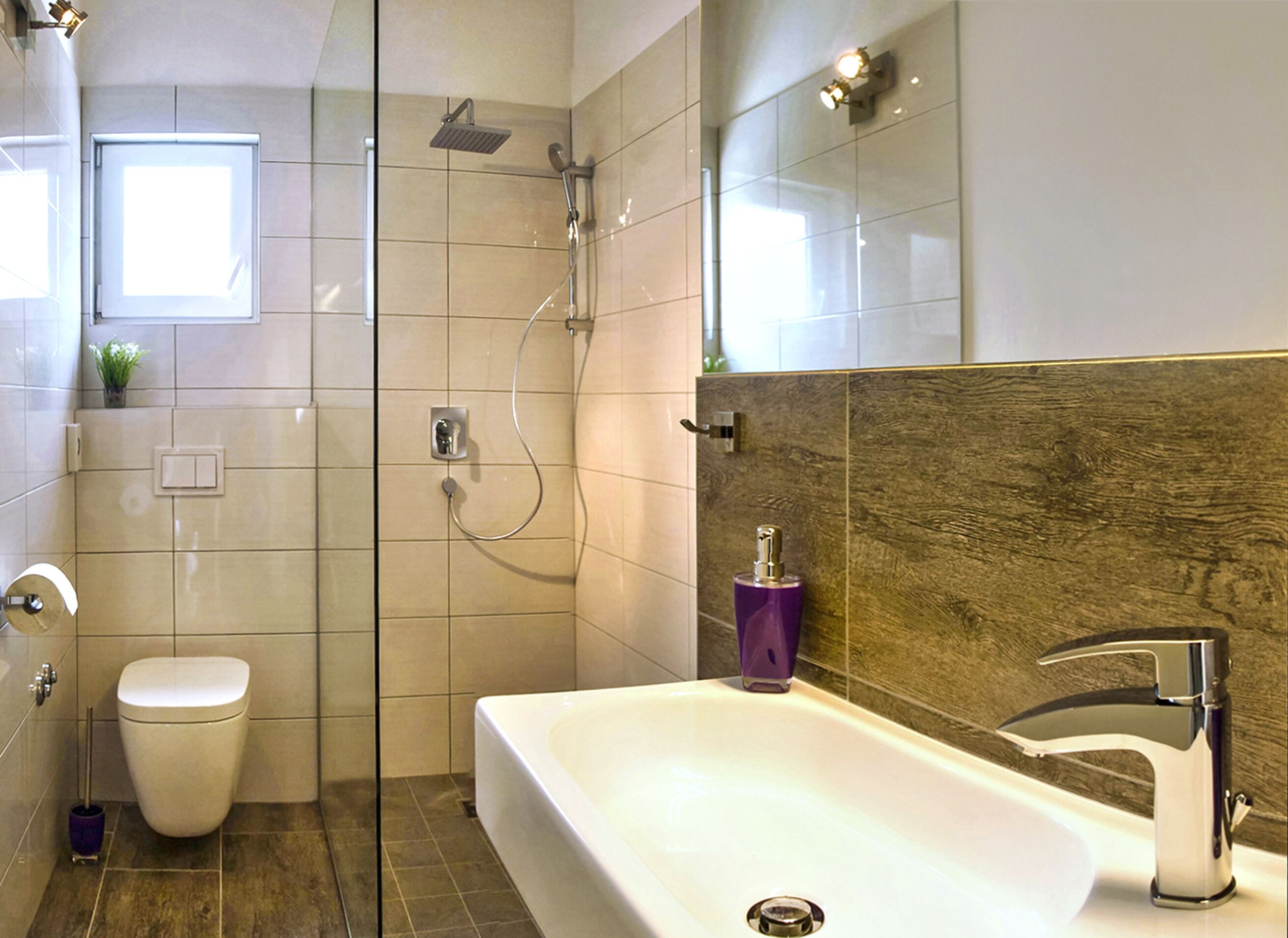 Une salle de bain moderne équipée d’une douche, de toilettes et d’une grande baignoire.