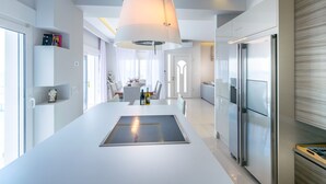 A modern kitchen with a central island, stainless steel appliances, and a pendant light.