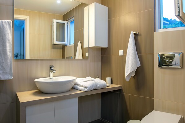 A modern bathroom with a large white sink, a mirror, a towel rack, and a toilet. - Luxury villa,heating pool superior facilities ideal for families, free transfer (Achlia)