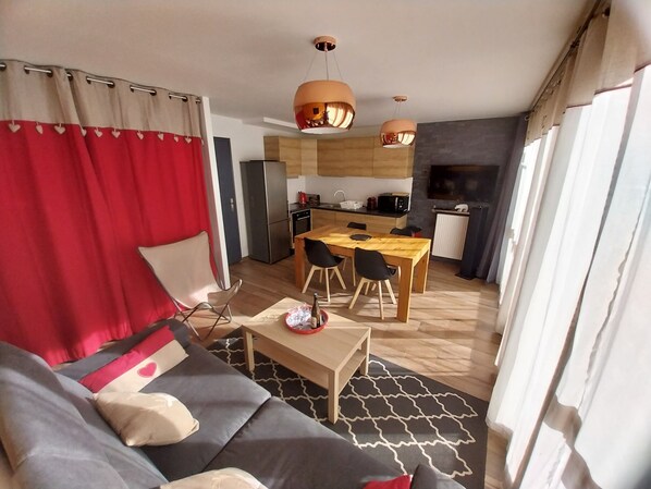A modern living room with a sofa, a coffee table, and a dining area with a wooden table and chairs. - Le Génépiste, Tignes Le Lac, Apartment 3*, 3 rooms, 50 m2 (Tignes)