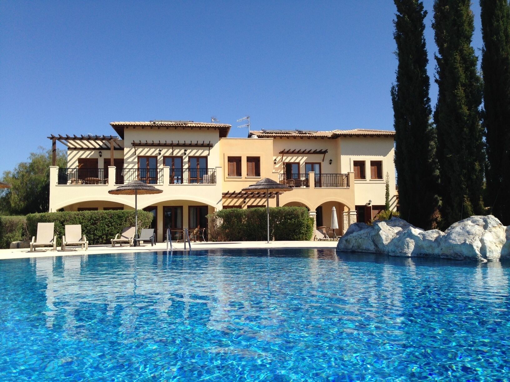A two-story building with a swimming pool in front.