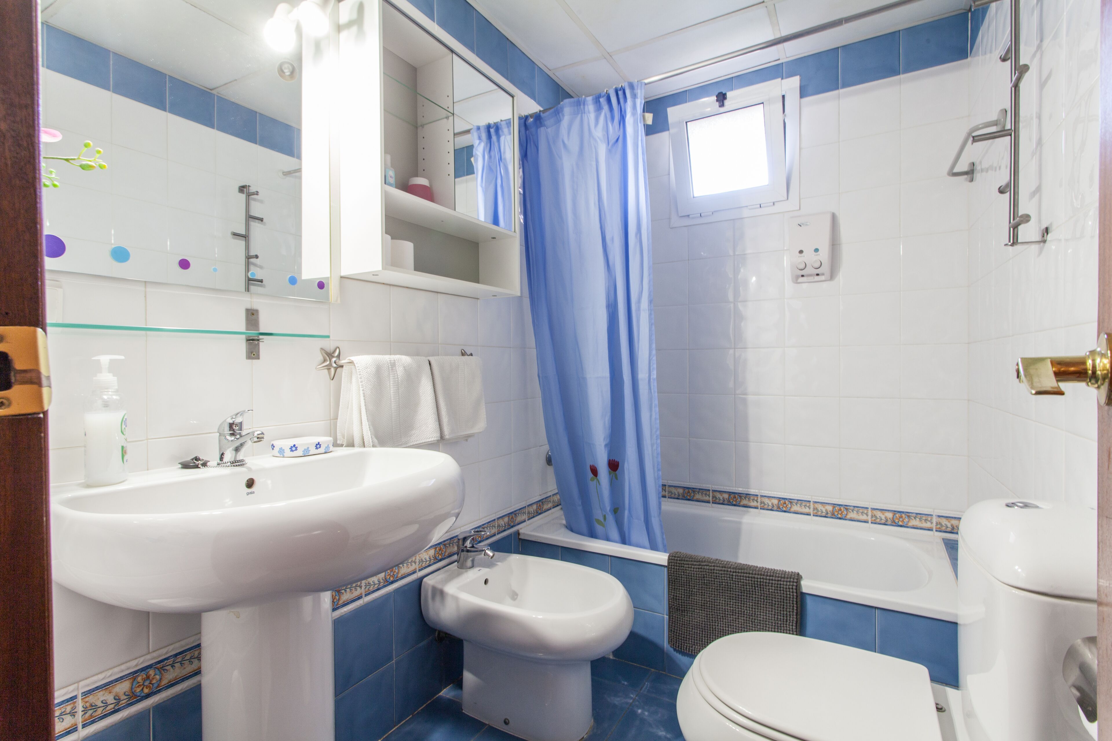 Un baño con lavamanos blanco, un bidé, inodoro y bañera.