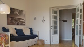 Ett sovrum med en säng, ett skrivbord och en stol. Det finns en dörr som leder till ett annat rum.
