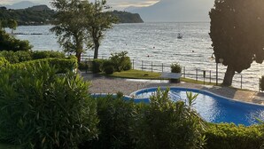 A pool area with a view of a lake and mountains in the background. - Direct Lake Access: Panoramic Pool, Jetty & Parking (manerba del garda)