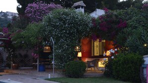 A garden with a pool, a patio, and a building with a yellow gate. - Modern villa on the beach, large private pool, BBQ, many flowers very quiet. (Almuñécar)