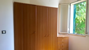 Un dormitorio con un armario de madera, un aparador y una cama.