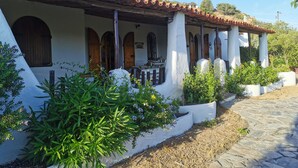A traditional building with a tiled roof, white walls, and wooden doors. - Villa - Eden Rock - Santa Margherita di Pula - House with garden (Domus de Maria)