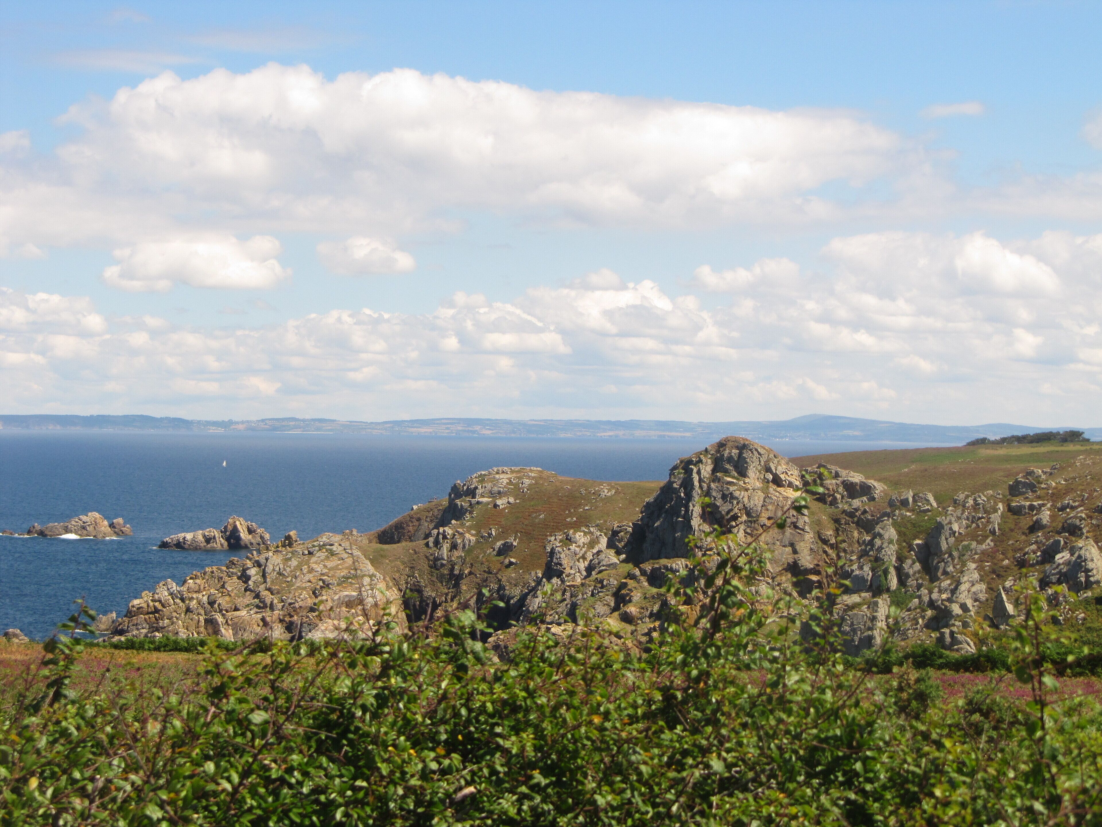 A coastal landscape with rocky terrain and a view of the sea.