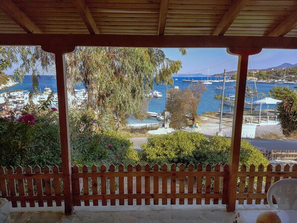 Zona exterior coberta amb tanca de fusta, vista d'un port esportiu amb vaixells i cel serè.