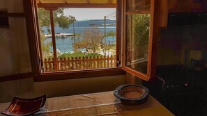 Una habitación con vista al puerto, un marco de ventana de madera y una pequeña mesa con un plato decorativo.