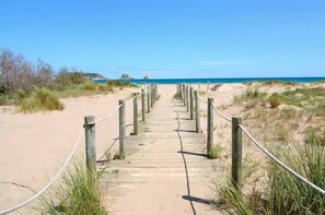 A wooden pathway leading to a beach with a clear sky. - L Estartit: HOUSE WITH POOL 150M FROM THE IDEAL BEACH FAMILIES SEA VIEWS (L´ESTARTIT)