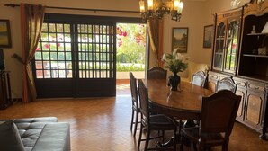 A dining area with a round table, chairs, a chandelier, a sofa, and a cabinet with glass doors. - 3 bedroom Villa, Private Pool, Private Location. Close to Guia, Near Albufeira Beaches & Old Town. (Guia)