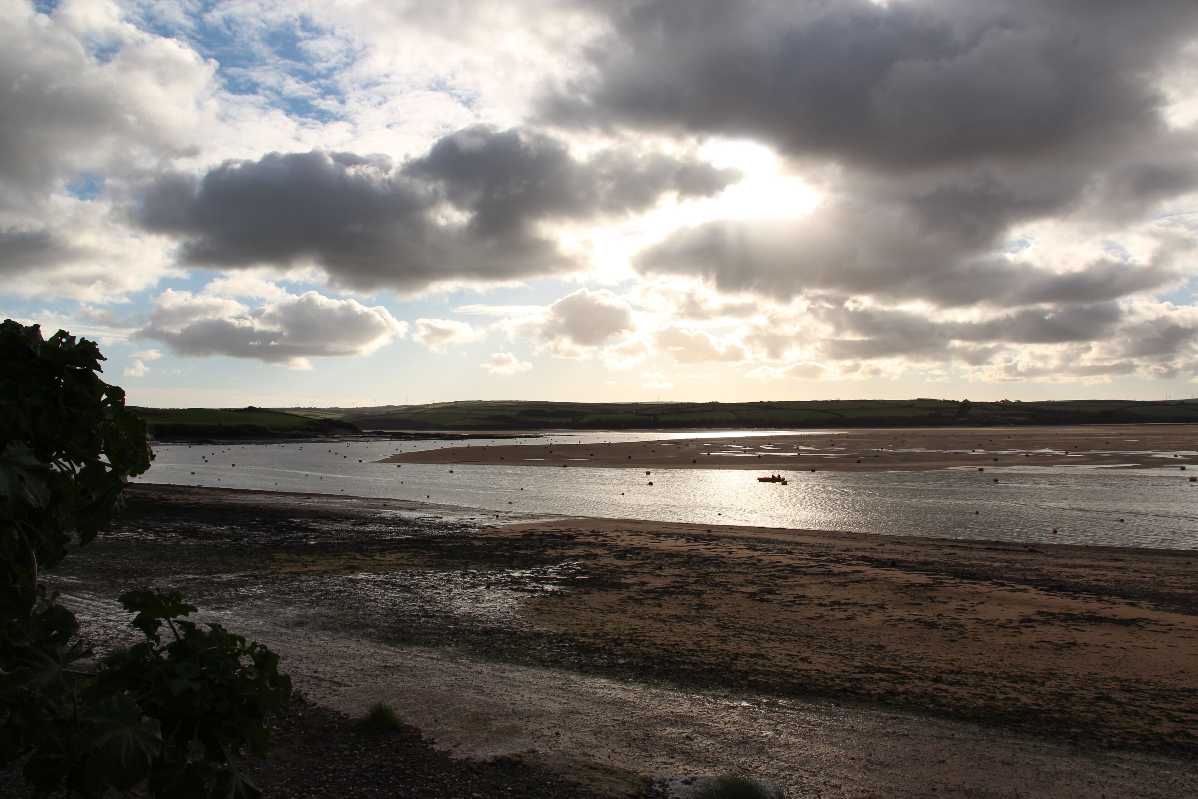 A coastal landscape with a wide sandy beach and a calm sea.