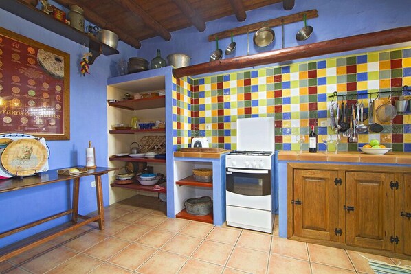 Cuina amb salabost a la paret, armaris de fusta i una cuina.