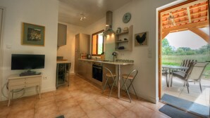 Una cocina con comedor, televisor y vista al exterior.