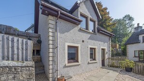 A two-story stone house with a sloped roof, a wooden fence, and a gravel driveway. - Sparkling Clean Fabulous views of Stirling Castle  (Stirling)