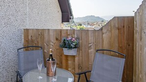 A patio with two chairs and a table, a bottle of champagne, and a flower pot. - Sparkling Clean Fabulous views of Stirling Castle  (Stirling)