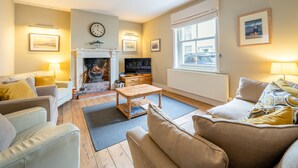 Una sala de estar acogedora con chimenea, asientos cómodos y televisor.
