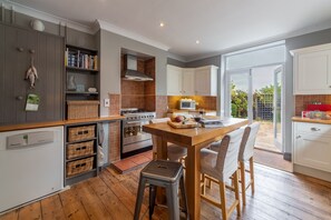 Una cocina moderna con una isla central, suelo de madera y vistas al exterior.