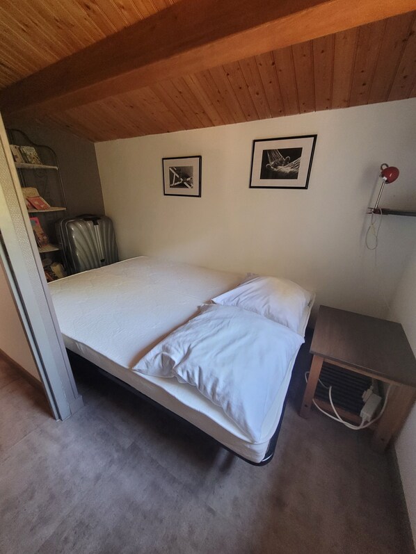 A compact bedroom with a single bed, a small bedside table, a red lamp, and two framed pictures on the wall. - House 6/8 people, 100m from the beach, on the edge of Longeville's Forest (La Tranche-Sur-Mer)