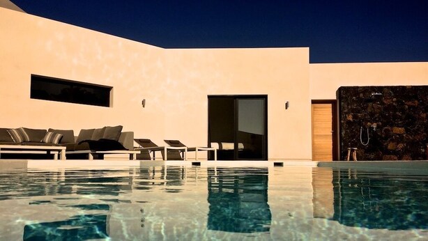 Un espace piscine moderne, doté de chaises longues et d’une eau cristalline.