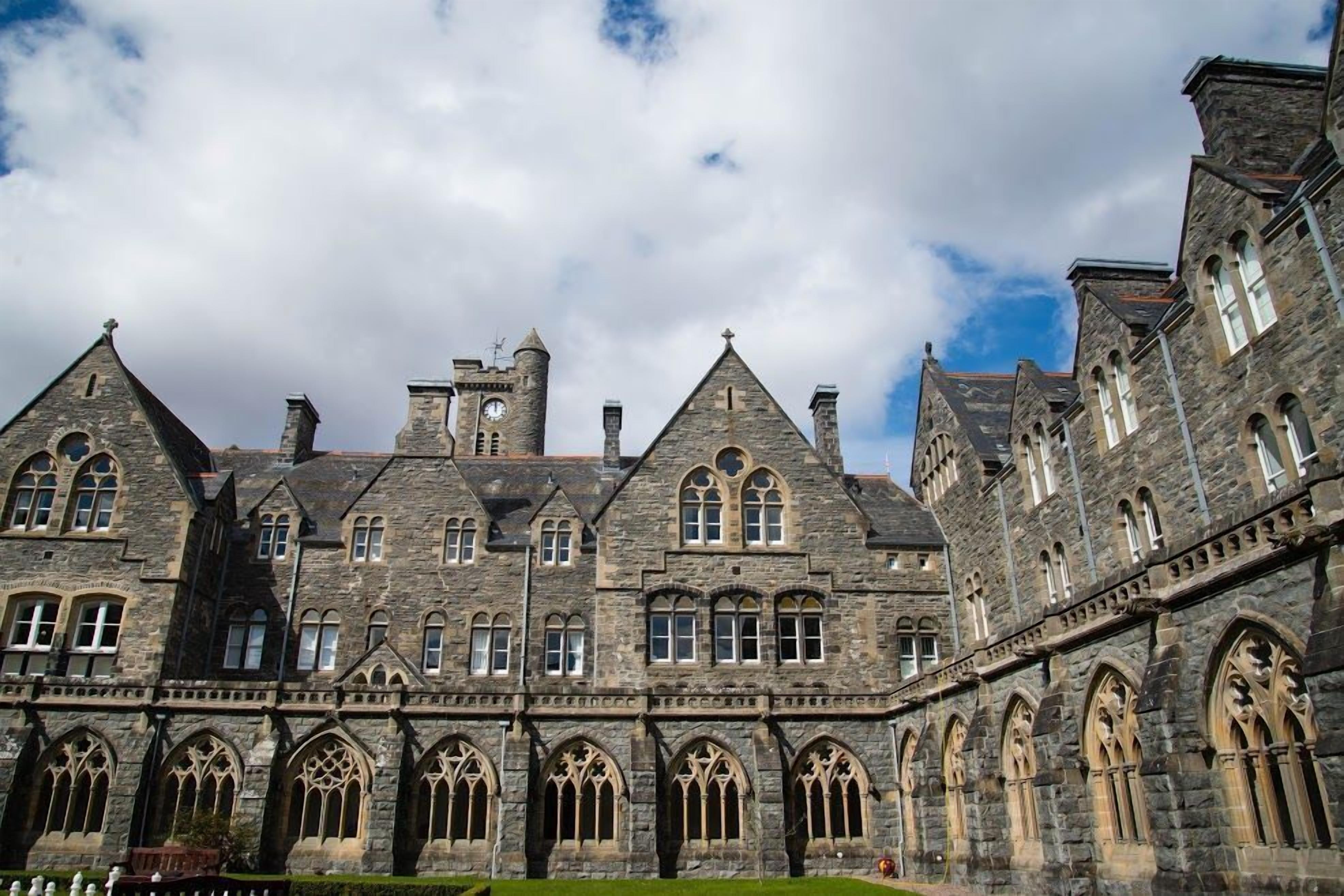 A historic stone building with multiple towers and arched windows.
