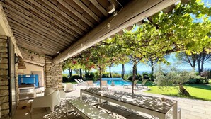 An outdoor patio area with a pool, lounge chairs, and a table.
