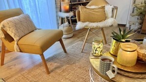 A cozy living room with a beige sofa, a round coffee table with decorative items, and a bookshelf in the background. - Luxury charm, terrace historic center Mazarin district with elevator (Aix-En-Provence)