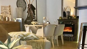 A cozy living room with a fireplace, a dining area, and a small round table with candles. - Luxury charm, terrace historic center Mazarin district with elevator (Aix-En-Provence)