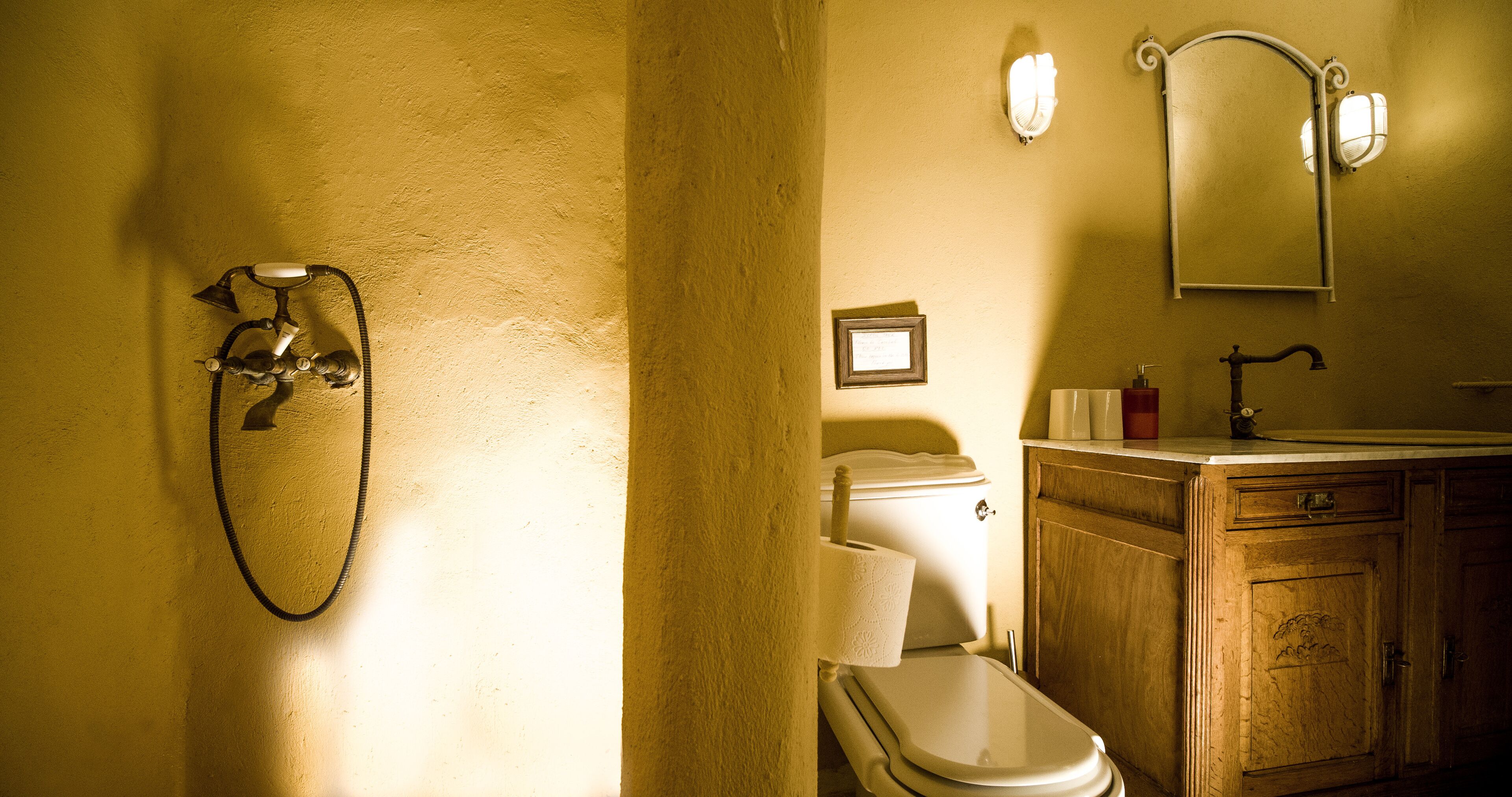 Een badkamer met een douche, toilet, wastafel en houten kastjes.